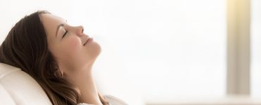 Young woman with eyes closed calm and relaxed on a sofa