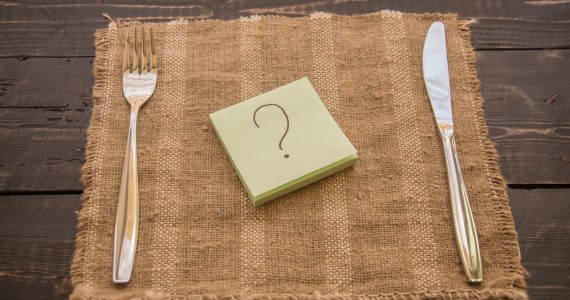 Post-it with a question mark in between a knife and fork to show diet questions