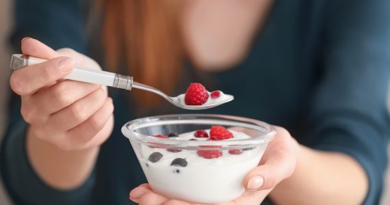 Close up of a woman wating yoghurt with fruit